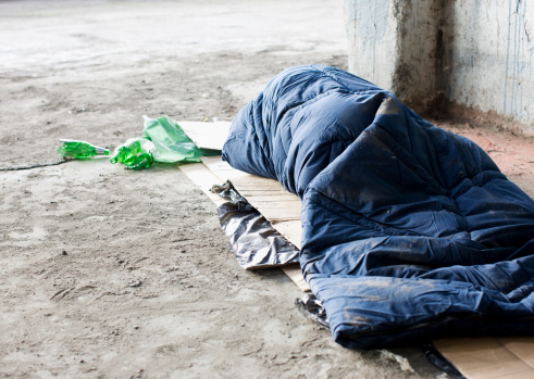 The Hope Hub preventing Homelessness - Homeless man sleeping in sleeping bag on cardboard